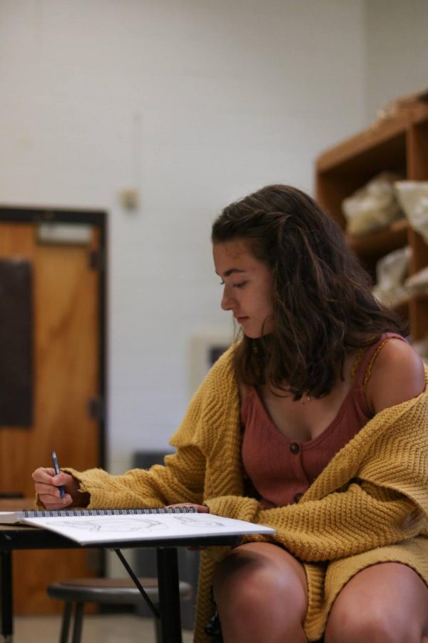 Landry draws in her class notebook. Landry has been in the art program since the 8th grade.