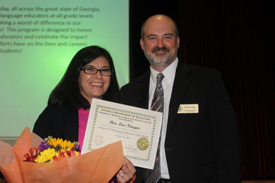 Vargas poses with presenter Patrick Wallace and the World Educator of the month award. This award is presented each month to an educator in the state of Georgia who shows exemplary dedication in the classroom.