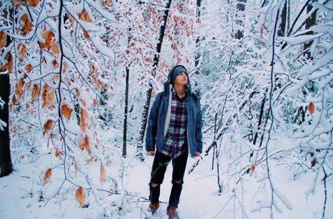 Senior Kalin Valone stands amidst a snowy landscape, gazing at the white vastness. Valone chose this spot for its quietness and lack of objects in the background that would distract from the photograph’s composition. Photo provided by Kalin Valone.