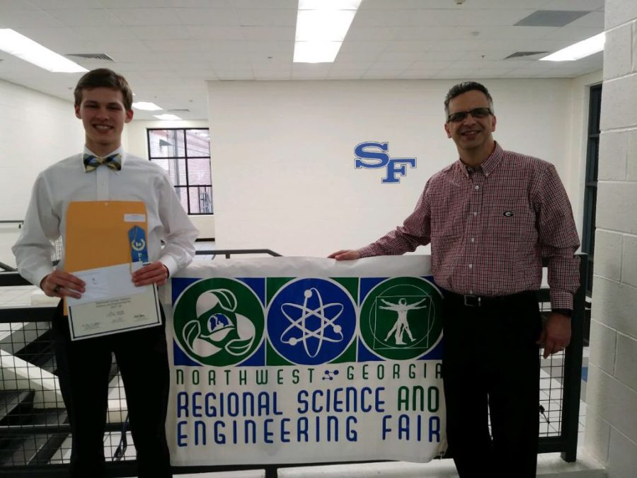Senior Teddy Campbell stands with his Advanced Placement (AP) chemistry teacher at the Northwest Georgia Regional Science and Engineering Fair. Campbell won first place at this event and will be attending the state fair in March.