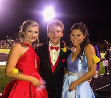 Sophomore Jack Piskorz poses with current seniors, Bailey Moore and Ella Avery, during half time after walking the field his freshman year. Piskorz’s favorite part about court was getting to dress up and walk the field. 