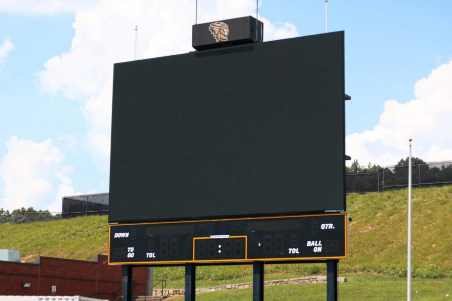 The+newly+placed+scoreboard+stands+tall+at+the+end+of+the+football+field.+The+scoreboard%E2%80%99s+installation+was+pushed+back+a+year.