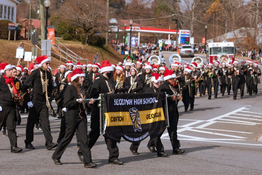 The+marching+band+leads+the+way+in+the+2021+Holly+Springs+Christmas+Parade.+2021+marked+the+first+and+last+year+of+Christmas+parades+for+many+band+members.